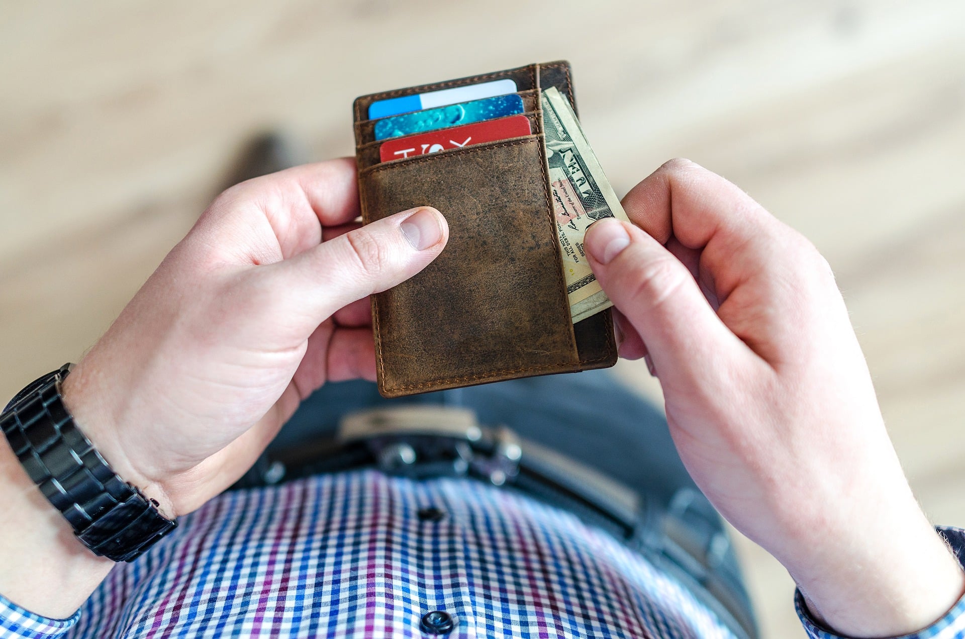 man pulling money out of wallet