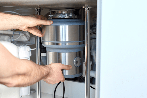 Man installing a new garbage disposal to replace a broken one