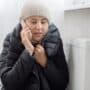 Woman in Winter coat with broken furnace.